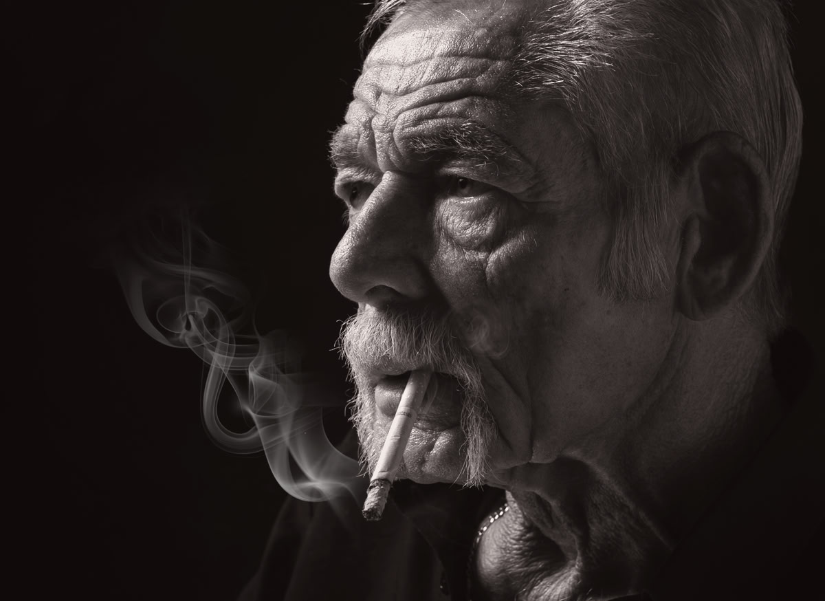 • Schwarz-Weiß-Fotografie  • Charakterporträt  • älterer Mann  • reifer Mann  • alter Mann  • rauchender Mann  • Zigarette  • Porträtfotografie  • Studiofotografie  • Seitenlicht  • Low Key Fotografie  • Fotokunst  • markantes Gesicht  • Ausdrucksstark  • Männerporträt  • Charakterstudie  • Schwarz-Weiß-Kunstfoto  • Fine Art Photography